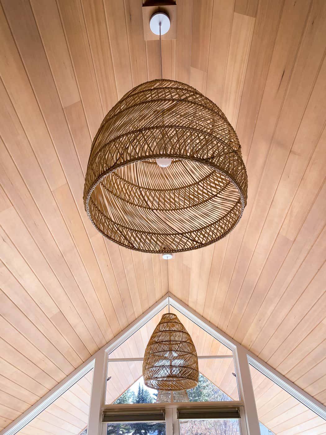 Wood paneled ceiling with basket woven lights in master bedroom